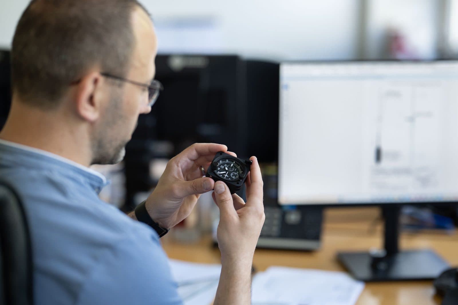 Ingénieur SATHOM inspectant un instrument de vol devant un plan technique