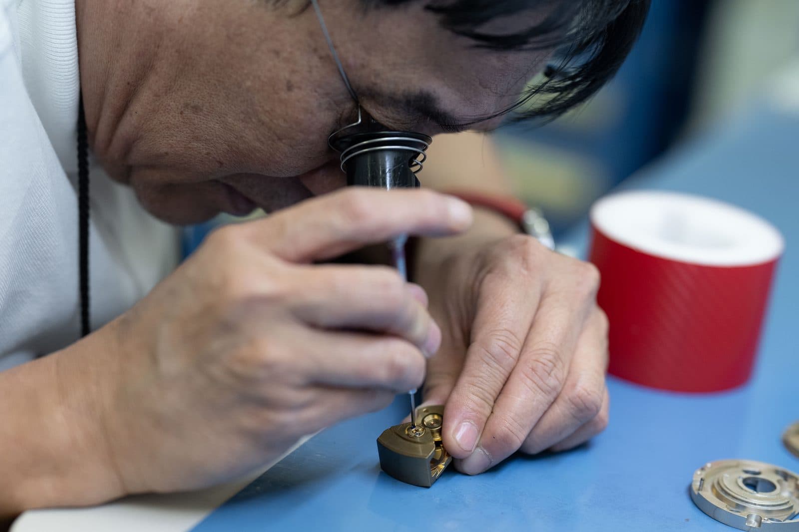 Technicien SATHOM intervenant à la loupe sur un instrument de précision